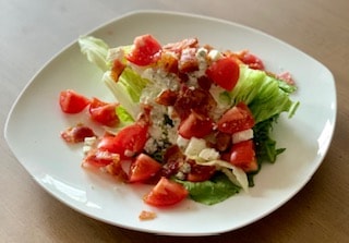Wedge salad with tomatoes, bacon and dressing